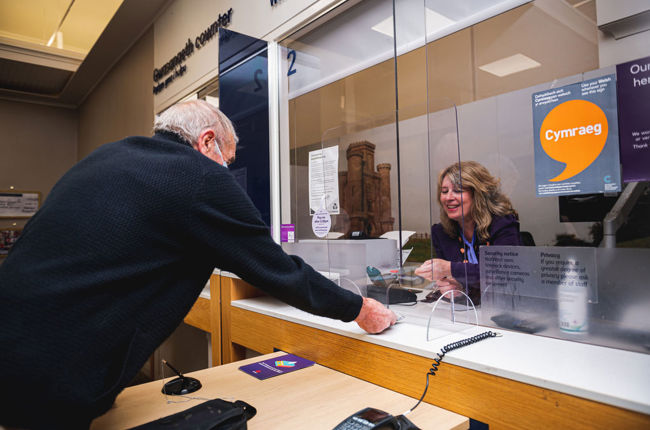 Dyn yn derbyn gwasanaeth gan aelod o staff Natwest