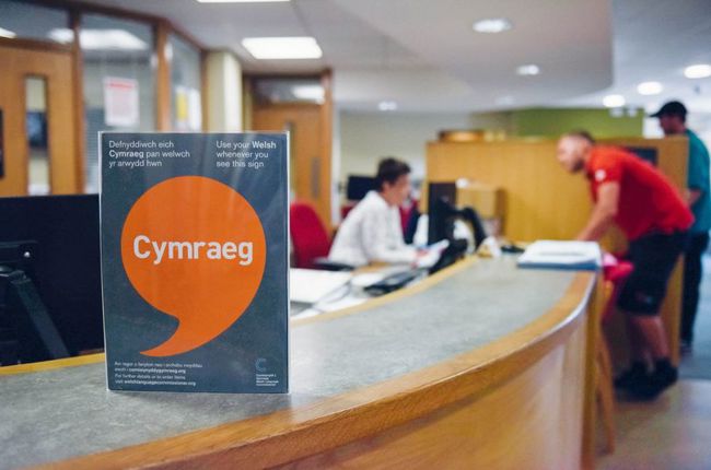Poster Iaith Gwaith ar ddesg