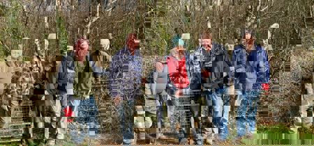 Gwirfoddolwyr o Ramblers Cymru yn sefyll mewn cae 