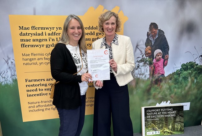 Comisiynydd y Gymraeg yn cyflwyno tystysgrif Cynnig Cymraeg i WWF